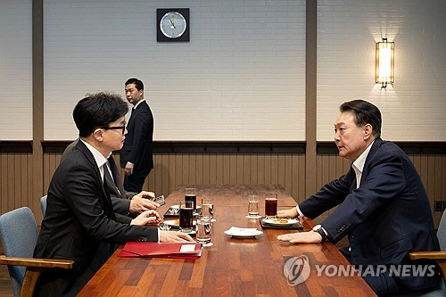 윤석열 대통령이 21일 서울 용산 대통령실 앞 파인그라스에서 국민의힘 한동훈 대표를 만나 대화하고 있다.  [대통령실 제공]